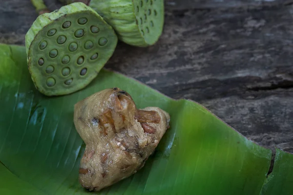 Zongzi ya da geleneksel Çin Yapışkan Pirinç Hamur köfteleri muz yaprağına sarılıp nilüfer tohumu ile süslenmiştir.