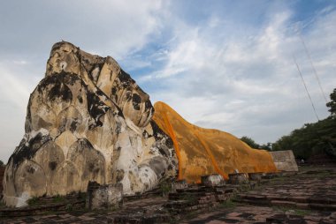 Büyük Buda heykeli Ayudhaya tarih parkında açık havada sarı kumaş giyiyor.