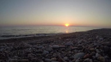 Parlak turuncu güneş ayarı Karadeniz içine Timelapse. Sunset bulvarında bir çakıl plajı