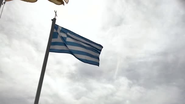 Η σημαία της Ελλάδας φτερουγίζει στον άνεμο φόντο του ουρανού. — Αρχείο Βίντεο