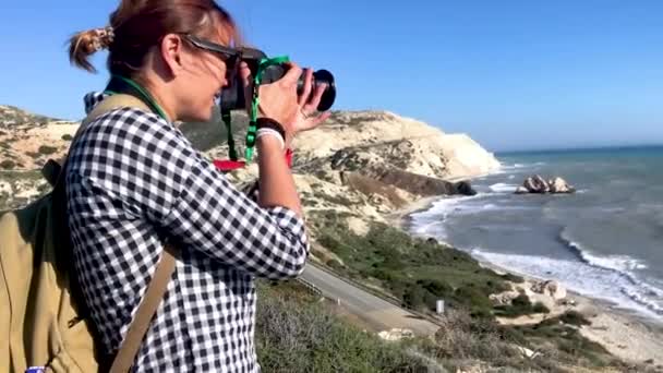 Молодая женщина-профессиональный фотограф фотографирует пейзаж . — стоковое видео