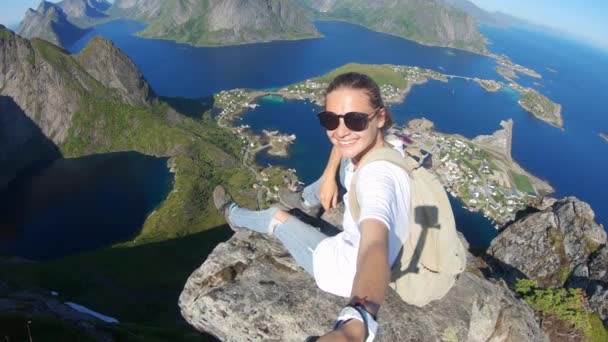 Young woman video blogger taking a selfie at the edge of a cliff with a top view — Stock Video
