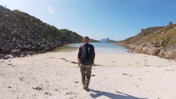 Jonge vrouw reiziger wandelen naar het strand bij de Noorse fjord. — Stockvideo