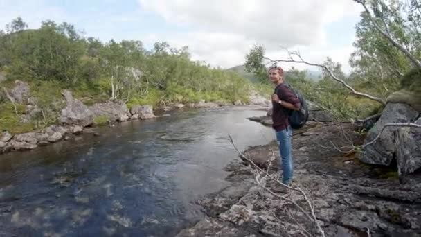 若い女性バックパッカーの山の川に立って — ストック動画