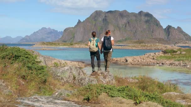 To unge kvinner som står og holder hendene i utkanten av en klippe. – stockvideo