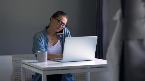 Jonge vrouw druk bezig thuis te werken met haar laptop — Stockvideo