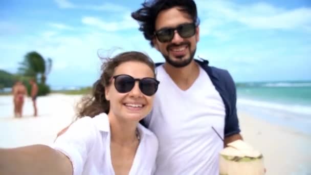 Mladý veselý pár vlogging na tropické pláži s výhledem na moře. — Stock video