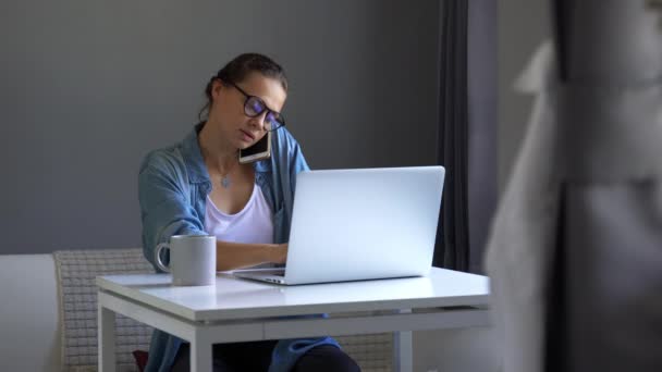 Fiatal nő elfoglalt dolgozik otthon használja a laptopját — Stock videók