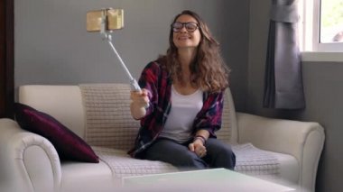 Neşeli genç yetişkin kadın blogcu kanal için çevrimiçi video kaydediyor