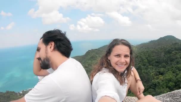 Una coppia amorevole seduta sulla collina con vista sul mare e farsi un selfie . — Video Stock