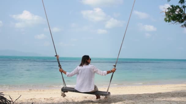 Una joven balanceándose en un columpio en la playa — Vídeos de Stock