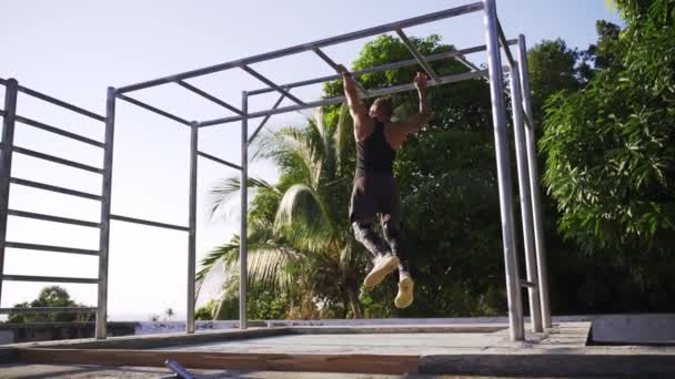 Hombre atlético haciendo ejercicio en un gimnasio al aire libre. Fuerza y motivación . — Vídeo de stock