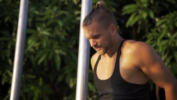 Hombre atlético haciendo ejercicio en un gimnasio al aire libre. Fuerza y motivación . — Vídeo de stock