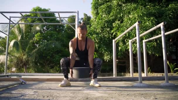 En atletisk man som tränar på ett utomhusgym. Styrka och motivation. — Stockvideo