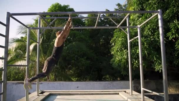 Hombre atlético haciendo ejercicio en un gimnasio al aire libre. Fuerza y motivación . — Vídeo de stock