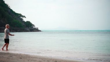 Slow-motion footage of woman throwing a frisbee at the tropical beach