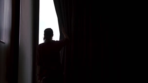 Uma jovem abre cortinas blackout — Vídeo de Stock