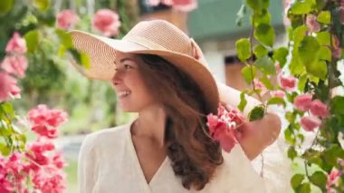 Portrait of a young cheerful caucasian woman in a big straw hat 