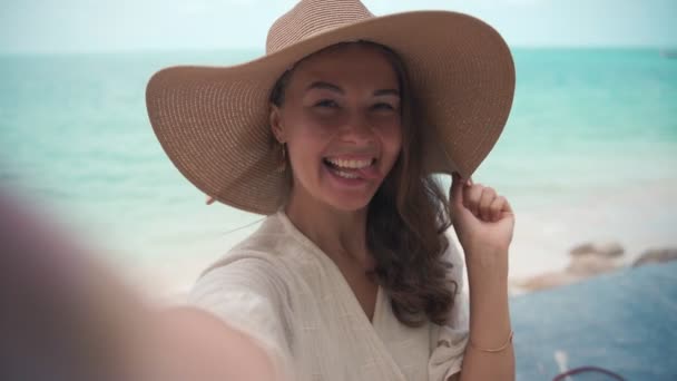 A young woman in a big straw hat taking a selfie — Stock Video