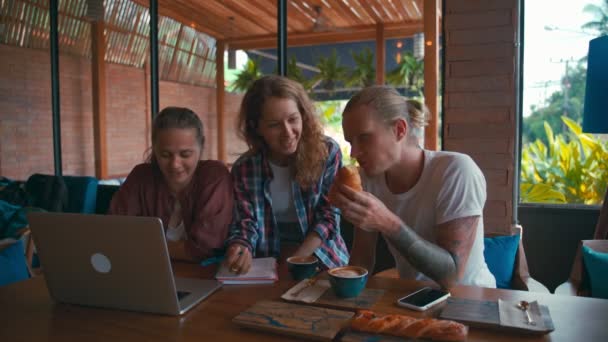 Équipe de jeunes collègues travaillant sur des ordinateurs portables et discutant d'affaires — Video