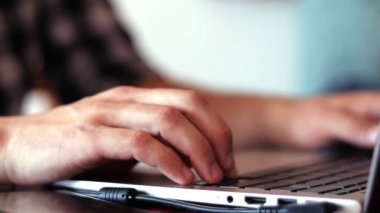 Adamın ellerinin dizüstü bilgisayarda bir şey yazarken yakın plan görüntüsü..