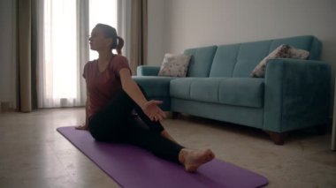 Yoga yapan çekici genç bir kadın evde yoga yapıyor..