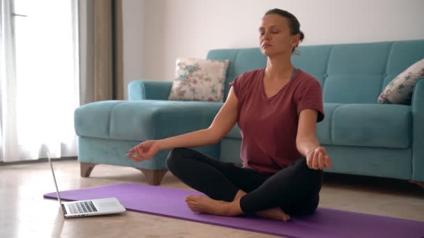 Atraktivní mladá žena dělá meditaci při práci z domova. — Stock video
