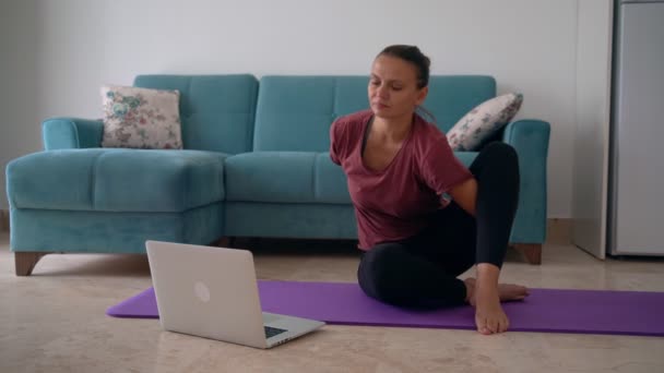 Приваблива молода жінка займається йогою розтягує йогу онлайн вдома . — стокове відео