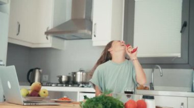 Genç beyaz kadın mutfakta yemek pişirirken eğleniyor.