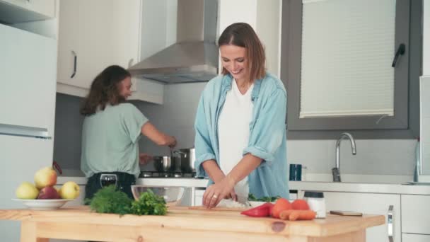 Két fiatal, csinos kaukázusi nő főz a fényes konyhában. — Stock videók