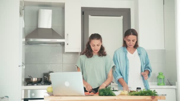 Dvě mladé krásné ženy vaří v jasné kuchyni — Stock video