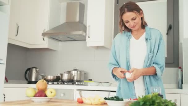 Jovem mulher caucasiana alegre se divertindo enquanto cozinha na cozinha — Vídeo de Stock