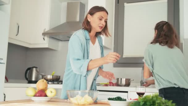 Zwei junge hübsche Frauen kochen schnell in der hellen Küche. — Stockvideo