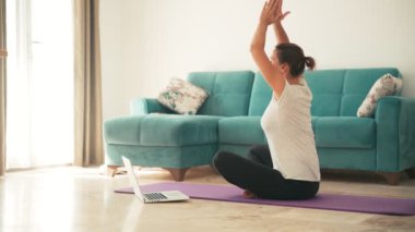 Yoga yapan çekici genç bir kadın evde yoga geriyor..