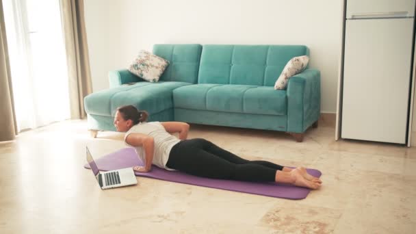Приваблива молода жінка займається йогою розтягує йогу онлайн вдома . — стокове відео