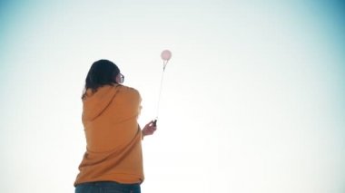 Çatı katında deniz manzaralı Poi topları yapan genç bir kadın.