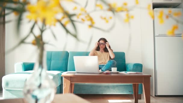 A young woman remote employee working from home with a laptop — Stock Video