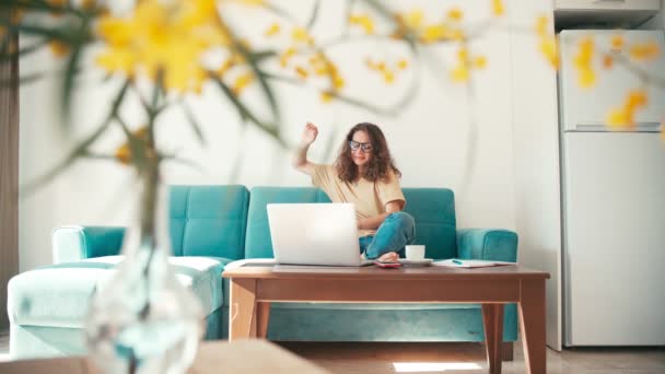 A young woman remote employee working from home with a laptop — Stock Video