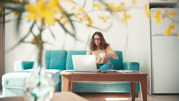 Una giovane donna dipendente remota che lavora da casa con un computer portatile — Video Stock