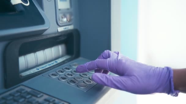 Mão das mulheres em luvas de látex protetoras usando uma máquina ATM . — Vídeo de Stock
