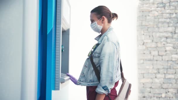 Femme dans un masque médical et gants de protection en latex à l'aide d'une machine ATM — Video