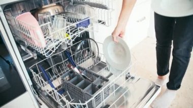 Bulaşık makinesini yükleyen kadının yakın plan fotoğrafı.