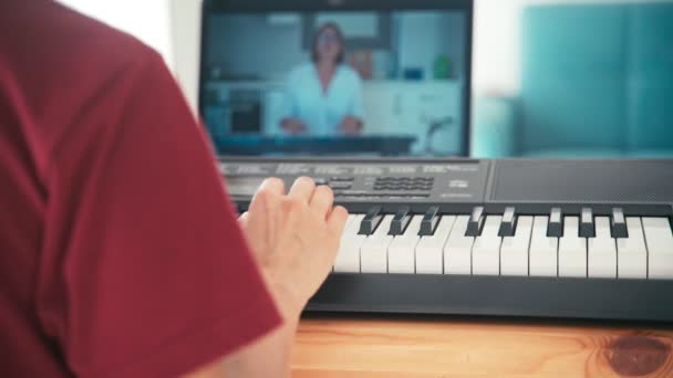 Un joven estudiante viendo lecciones de música en línea y estudiando desde casa . — Vídeo de stock