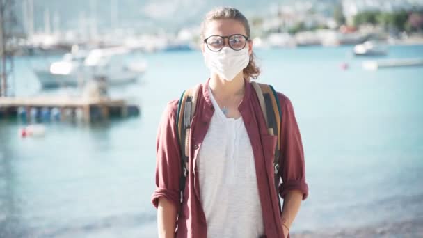 Portrait d'une jeune femme portant un masque médical protecteur regardant la caméra — Video