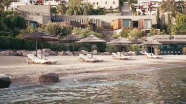 Lüks otel plajında el kamerasıyla boş şezlongların görüntüsü. Kimse..