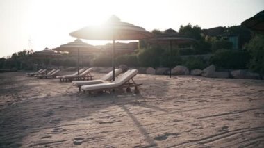 Lüks otel plajında el kamerasıyla boş şezlongların görüntüsü. Kimse..