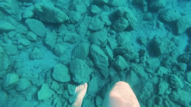 POV slow motion underwater shot of woman swimming in clear blue water. — Stock Video