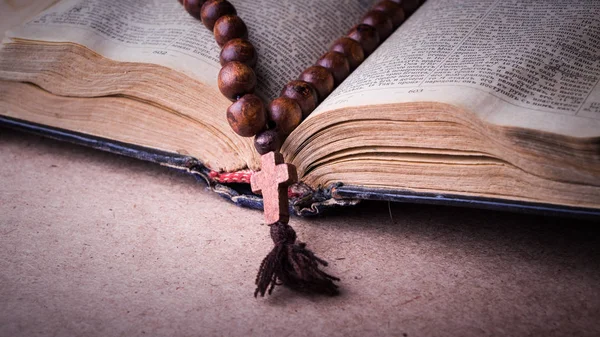 Rosario en la Biblia sobre un fondo de madera. Libro sagrado . —  Fotos de Stock