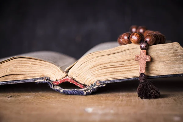 Rosario sulla Bibbia su uno sfondo di legno. Libro sacro . — Foto Stock