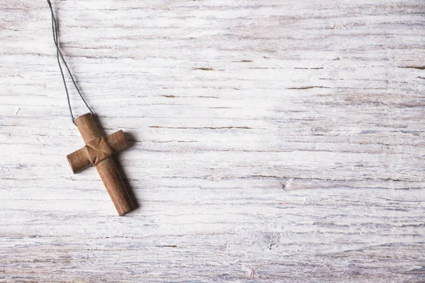 Croce marrone su uno sfondo di legno bianco — Foto Stock